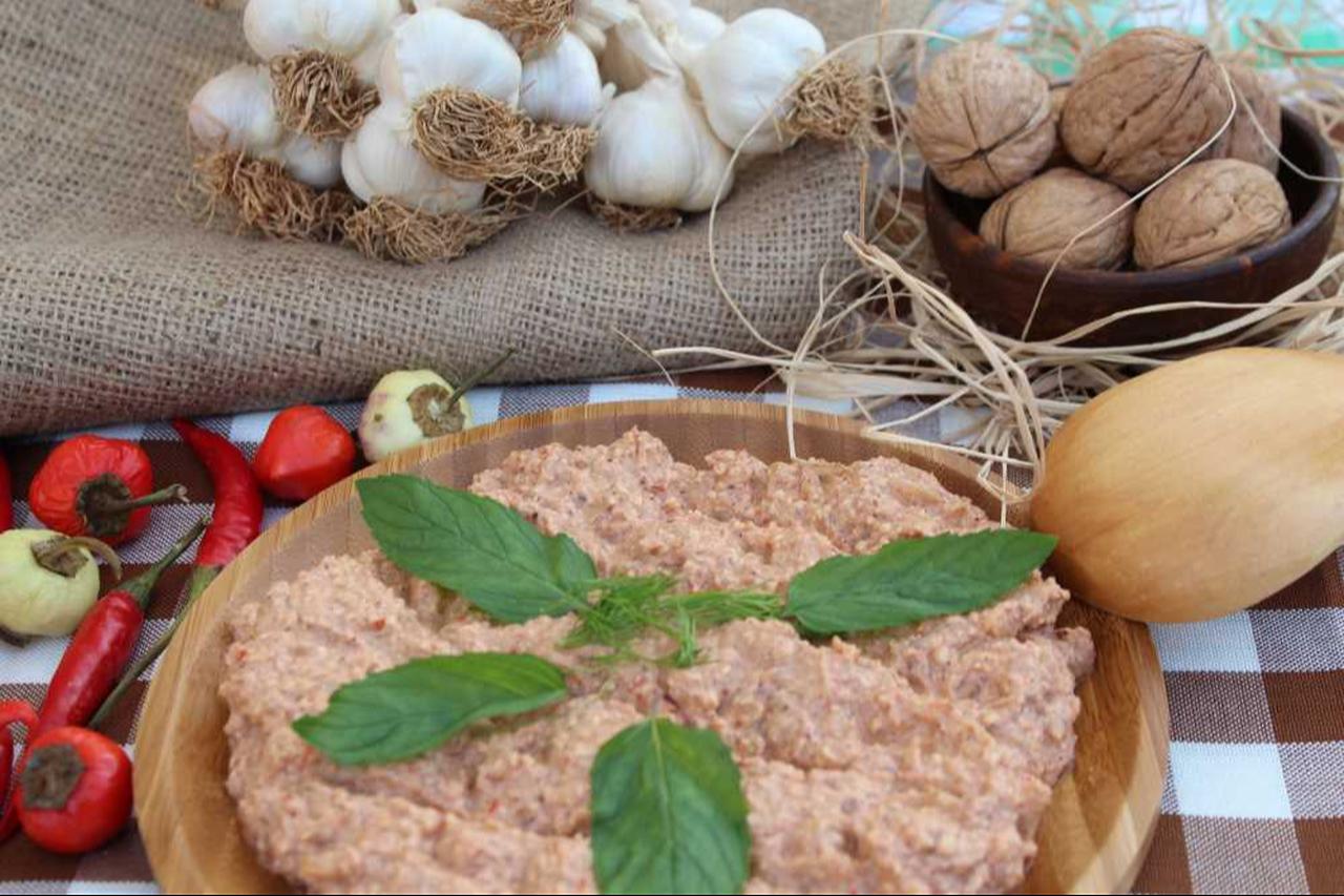A plate of Çerkez tavuğu topped with chopped walnuts, fresh coriander and a drizzle of seasoned oil. (Photo via Arda’nın Mutfagi)