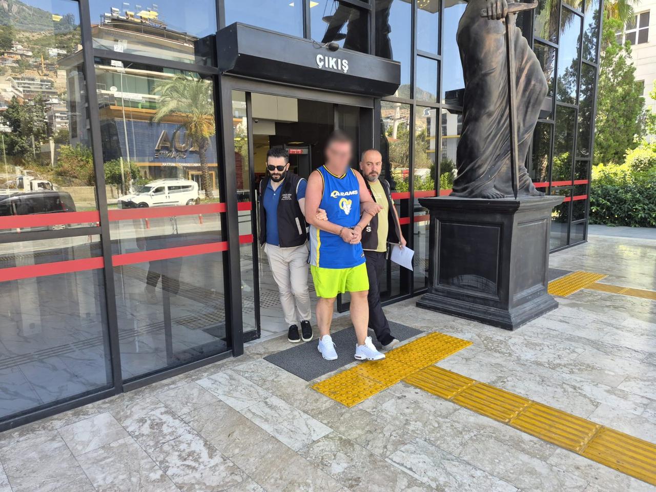 British tourist Stephen Kerr is escorted by police officers in Alanya, Antalya, Türkiye, after being detained over an incident involving a Turkish flag, Sept. 9, 2026. (IHA Photo)