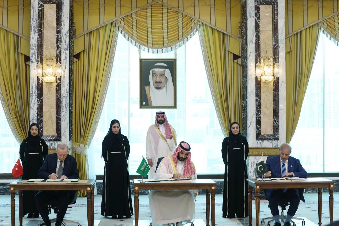 President Recep Tayyip Erdogan (L), Saudi Crown Prince Mohammed bin Salman (C), and Pakistani Prime Minister Shehbaz Sharif (R) sign a trilateral defense agreement in Mecca, Saudi Arabia, Aug. 7, 2026. (Turkish Presidency/Murat Cetinmuhurdar/Handout)