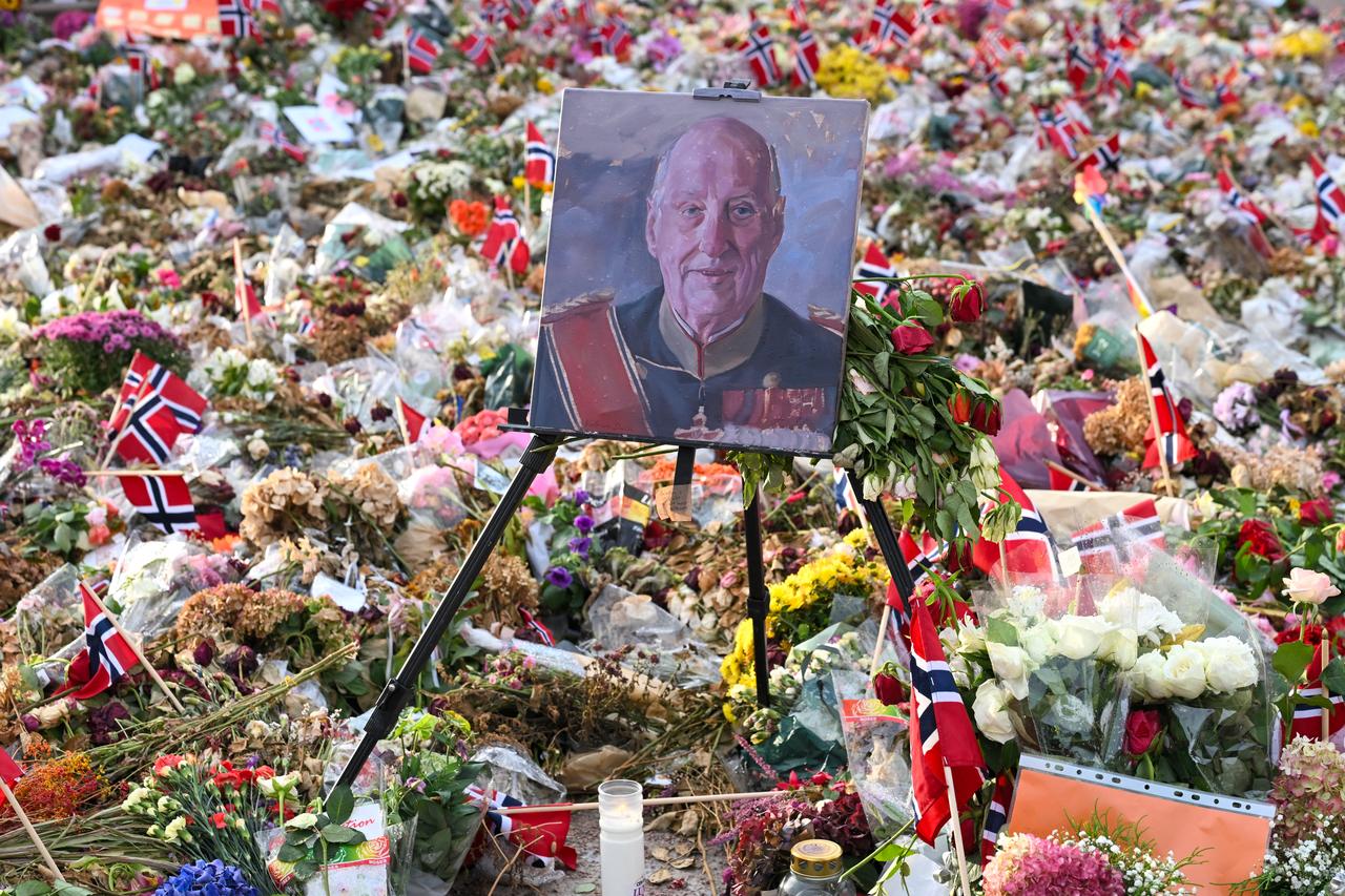 A portrait of the late King Harald V of Norway is displayed among flowers and Norwegian flags laid outside the Royal Palace in Oslo, Norway, on September 8, 2026. (AFP Photo)