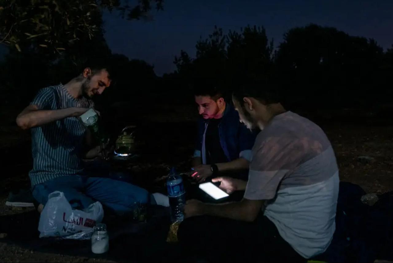 Khalid Najim, left, Mustafa al-Jaafar and Ali al-Dalaati drinking mate at a park in Idlib, Syria. (Photo by Nicole Tung for The New York Times)